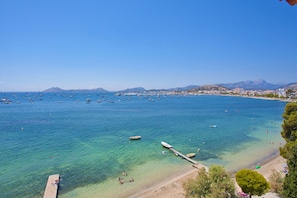 Eine Küstenlandschaft mit klarem, blauem Wasser, Booten und einem Strand.