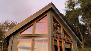 Een modern huis met grote ramen en een schuin dak.