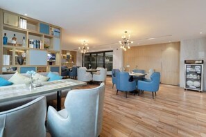 Eine moderne Hotelhalle mit Essbereich, Sitzgelegenheiten und einer Rezeption.
