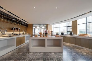 Una cocina moderna con una isla central, electrodomésticos integrados y grandes ventanales.