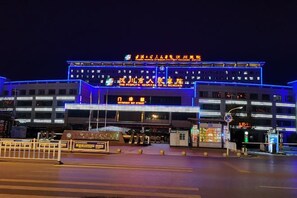 A multi-story building with illuminated signage and a prominent entrance. - Jinhua Tian Hotel (Hanchuan)