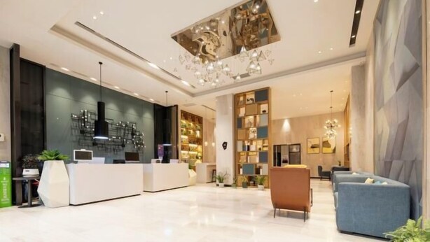 Eine moderne Hotellobby mit einer Rezeption, einer Sitzecke und dekorativen Elementen.