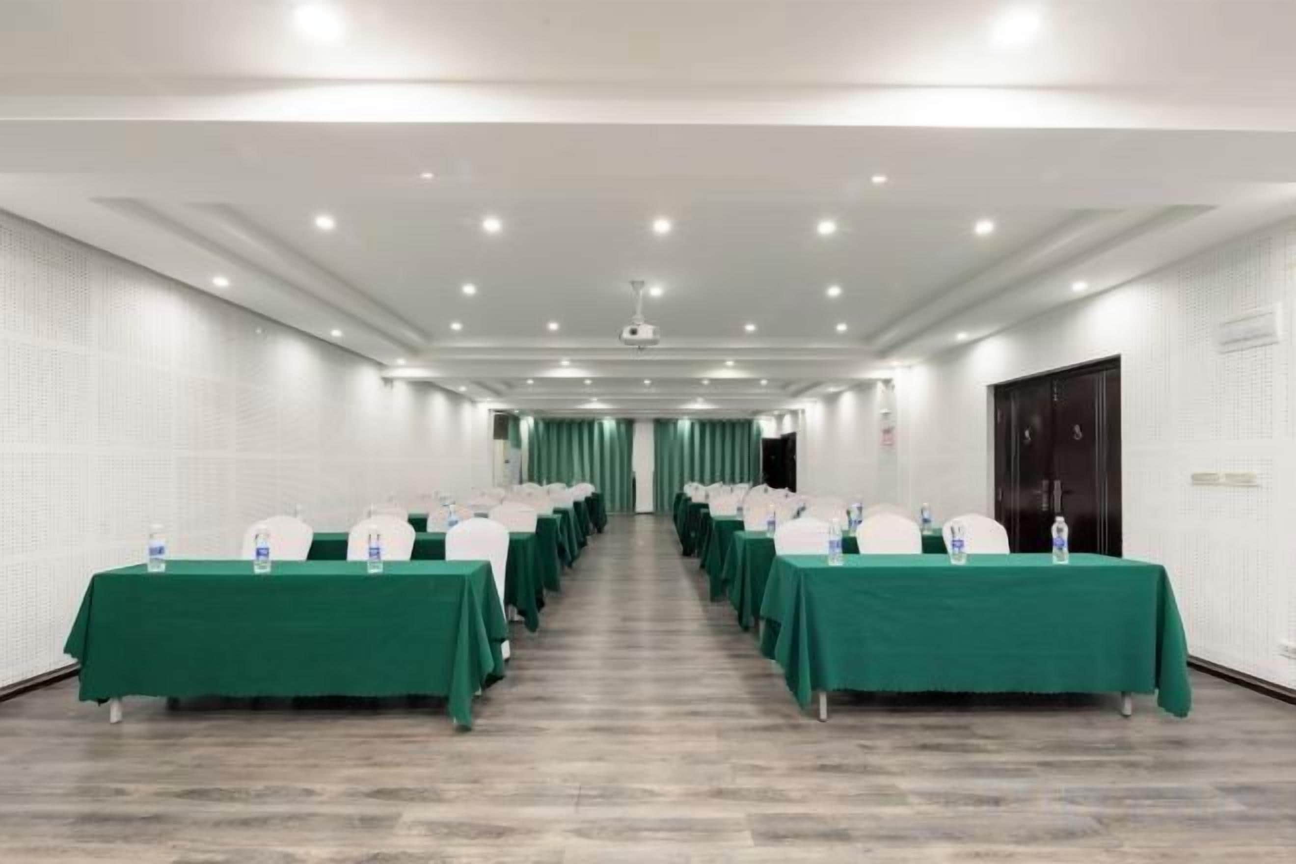 A conference room with rows of tables, each with a nameplate and water bottle.