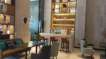 Un interior moderno con una zona de bar, asientos y estantes decorativos.