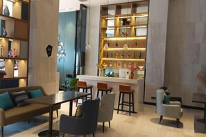 Ein modernes Interieur mit Barbereich, Sitzgelegenheiten und dekorativen Regalen.