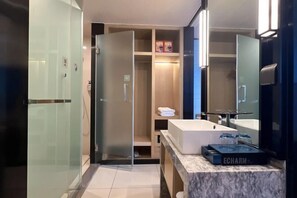 A modern bathroom with a glass shower enclosure, a white sink, and a vanity with a marble countertop. - Jinhua Tian Hotel (Hanchuan)