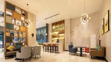 Un moderno vestíbulo de hotel con una zona de estar, un bar y una estantería.