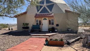 Una casa amb un teulat de disseny geomètric, una porta d'entrada i un camí que condueix a la façana.