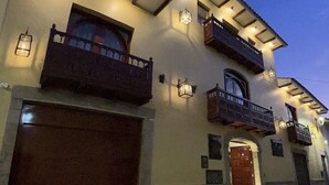 Ein zweigeschossiges Haus mit Garage, Balkon und einer Tür.