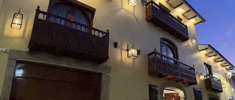 A two-story house with a garage, a balcony, and a door.