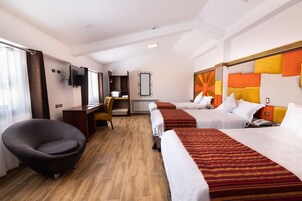 Ein Hotelzimmer mit zwei Betten, einem Schreibtisch, einem Stuhl, einem Fernseher und einem großen Spiegel.