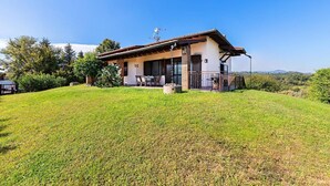 A single-story house with a patio, surrounded by a grassy lawn and trees. - Fantastic Villa in Soiano del Lago  for 6 people with pool  (Soiano del Lago)