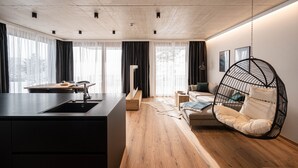 Eine moderne Küche mit schwarzer Arbeitsplatte und Spüle, einem Holzespeisetisch und einem Pendelstuhl.