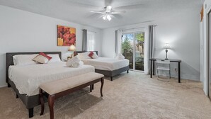 A hotel room with two beds, a bench, a desk, and a ceiling fan. - Spacious Home- Centrally located near St. Paul  (Little Canada)