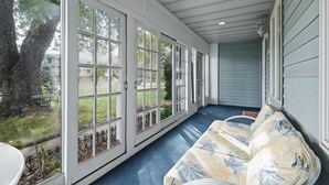 A covered porch with a blue floor, white walls, and a bench. - Spacious Home- Centrally located near St. Paul  (Little Canada)