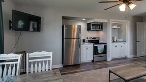 A modern kitchen with stainless steel appliances, a flat-screen TV mounted on the wall, and a ceiling fan. - The Loft at Hilltop Acres - Clarksville, Tennessee (1335 Whitt Ln) (Clarksville)