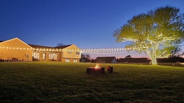 A large building with a grassy lawn, a fire pit, and string lights. - The Loft at Hilltop Acres - Clarksville, Tennessee (1335 Whitt Ln) (Clarksville)