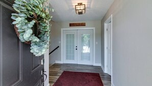 A hallway with a dark door, a red carpet, and a sign above the door that reads "SERVE THE LORD". - The Loft at Hilltop Acres - Clarksville, Tennessee (1335 Whitt Ln) (Clarksville)