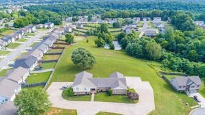 A residential area with houses, green lawns, and a central driveway.