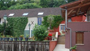 Ein traditionelles Gebäude mit Ziegeldach, Holzzaun und Topfpflanzen.