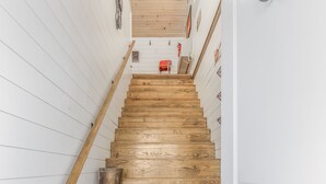 A wooden staircase with white walls and a wooden ceiling.