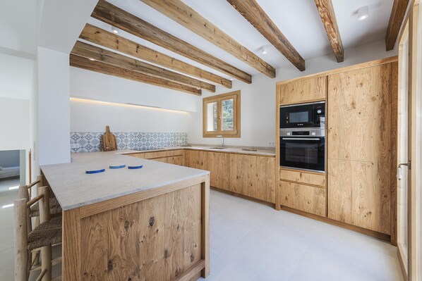 A kitchen with wooden cabinets, a built-in oven, and a window with a view.