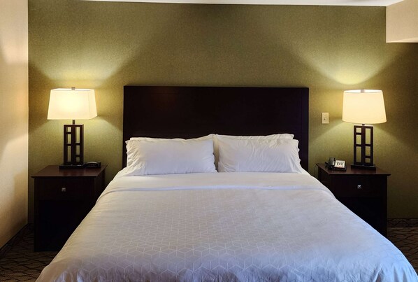 Relax in a spacious room with a large bed, two bedside tables, and a lamp on each.