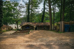 Un chalet rustique doté d’une cheminée, d’un porche couvert et d’une petite terrasse.