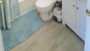 A bathroom with a bathtub, toilet, and sink. - Comfortable and affordable condo in four seasons. Monthly Discount Available. (Village of Four Seasons)