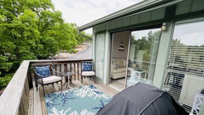 A deck with outdoor furniture, a patterned rug, and a sliding glass door leading to a room. - Comfortable and affordable condo in four seasons. Monthly Discount Available. (Village of Four Seasons)