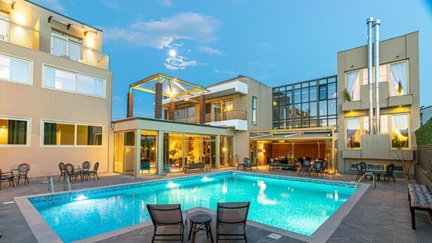 Um hotel moderno com piscina, área de estar ao ar livre e um terraço coberto.