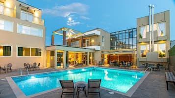 Una piscina al aire libre de temporada, sillones reclinables de piscina