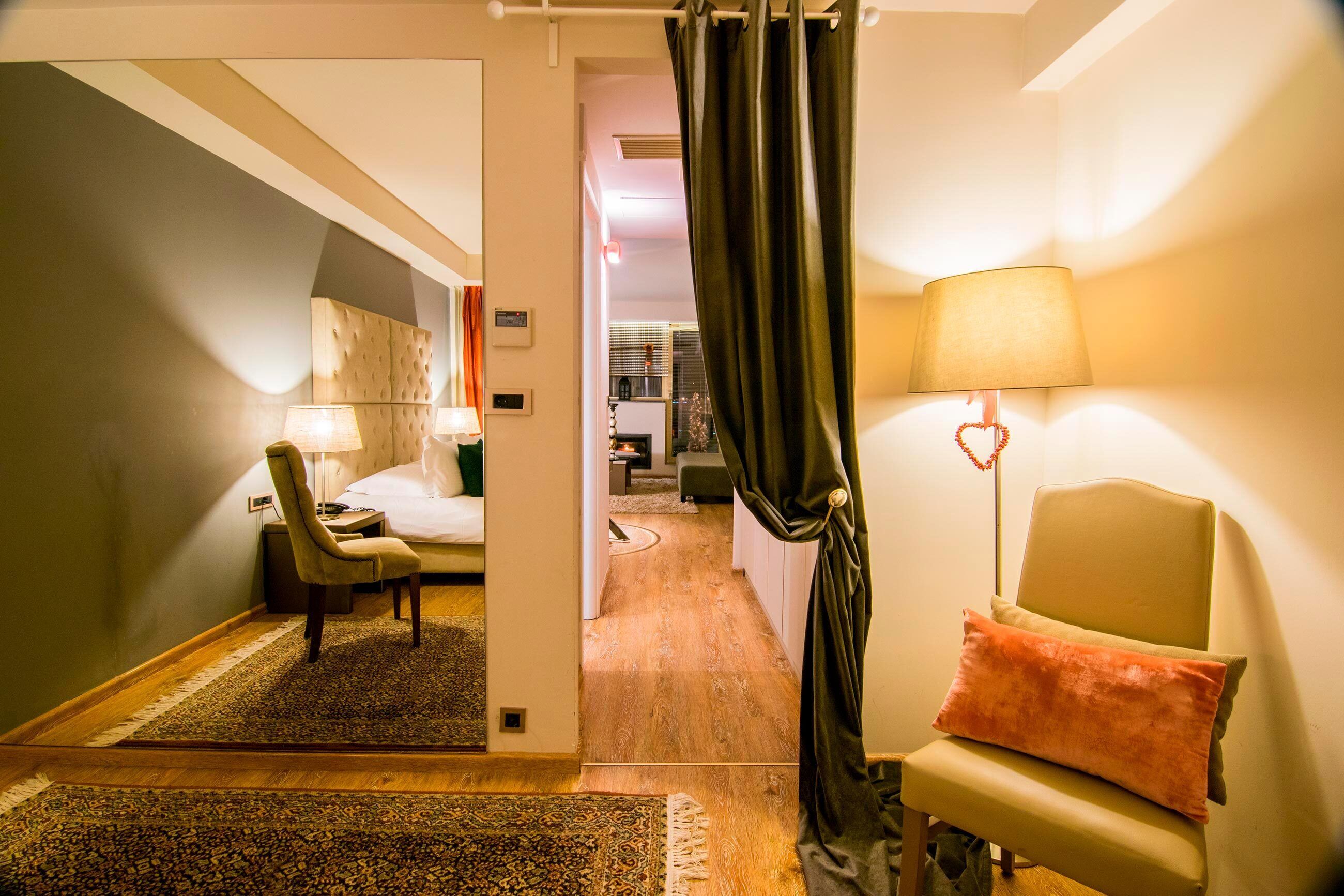 Une chambre d’hôtel avec un lit, une chaise, un bureau, une lampe et une vue sur le couloir.