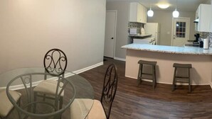 A modern kitchen with a central island, bar stools, and pendant lighting.