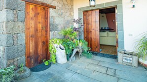 Un edificio de piedra con puertas de madera y un patio cubierto.