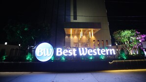 A hotel entrance with illuminated signage reading 'Best Western.'