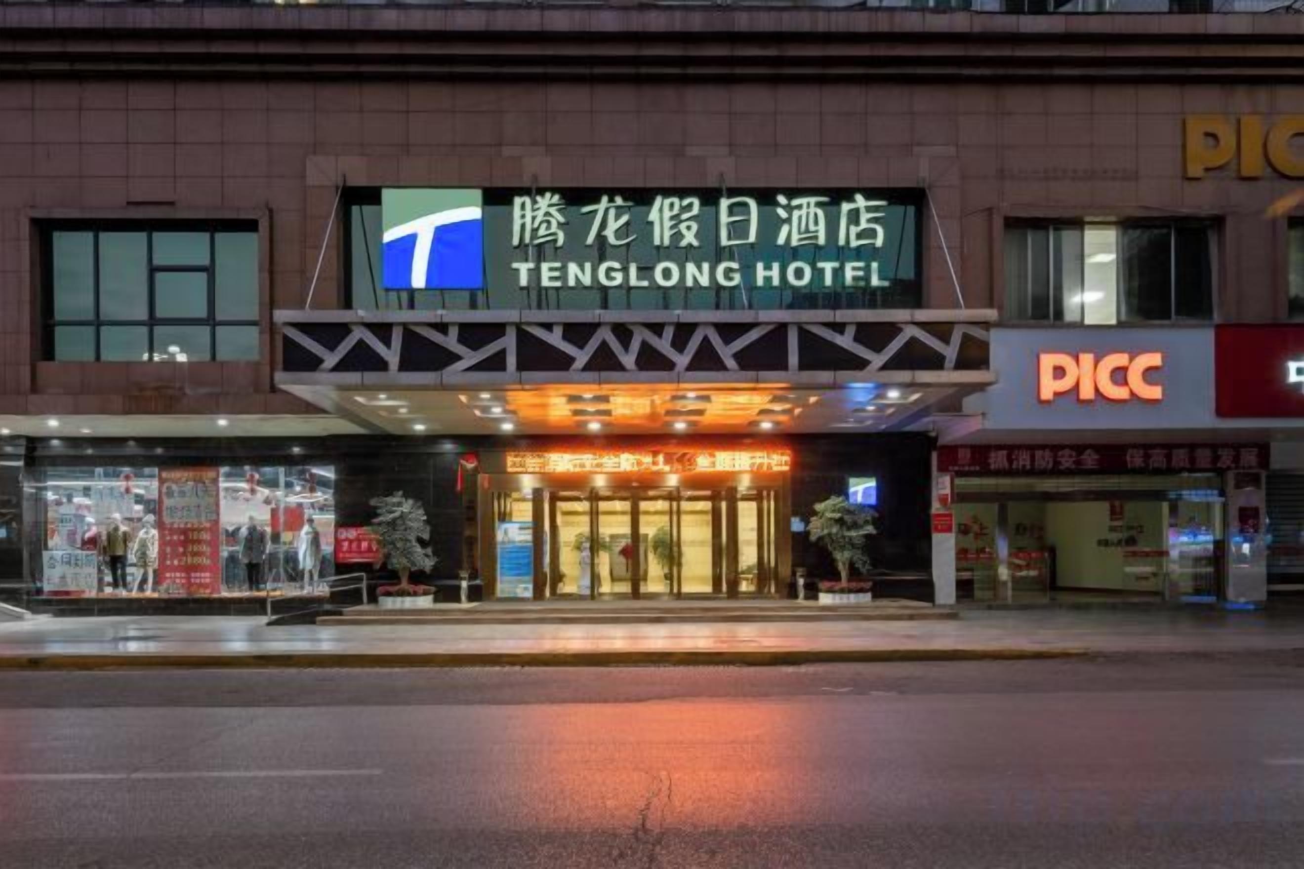Et hotel med et tydeligt skilt, en overdækket indgang og en synlig butiksfacade.