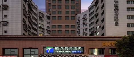 A hotel with a prominent sign, multiple floors, and a modern architectural design.