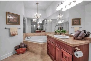 A bathroom with a freestanding bathtub, a vanity with a sink, and a large mirror.