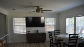 A dining area with a round table and chairs, a ceiling fan, and a flat-screen TV mounted on the wall. - Lakeview and direct access Boat Dock Lake Lewisville - Frisco/Little Elm
 (Frisco)