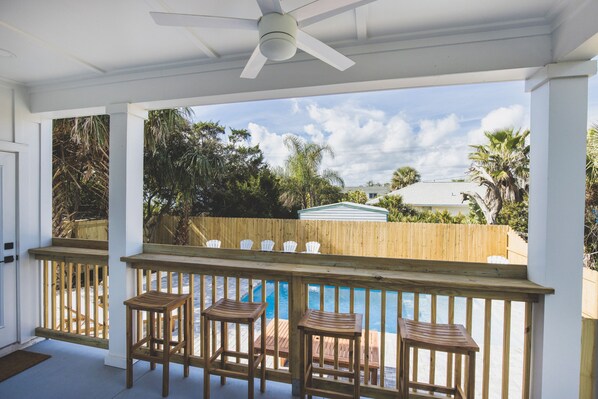 A covered outdoor area with a pool, wooden deck, and a ceiling fan. - Walk to Beach! Heated Pool • Boat Parking • EV Charger (St. Augustine)