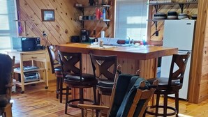 A cozy wooden interior with a dining area, kitchen, and seating space. - Toddy's Cabin (Trempealeau)