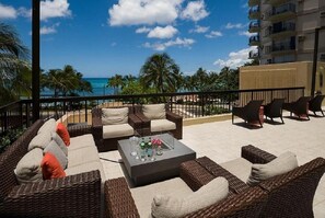 Relax in style with comfortable wicker sofas and armchairs surrounding a central coffee table on this oceanfront terrace.