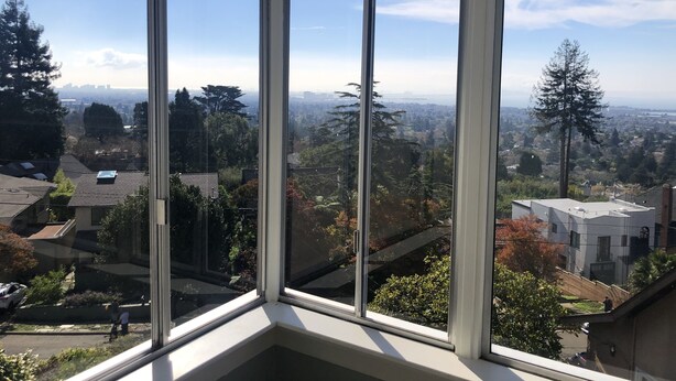 Una stanza d'angolo con ampie finestre e vista sulla città.