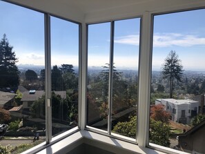 A corner room with large windows offering a city view. - Amazing Bay Area Views -- Gracious Living (Berkeley)