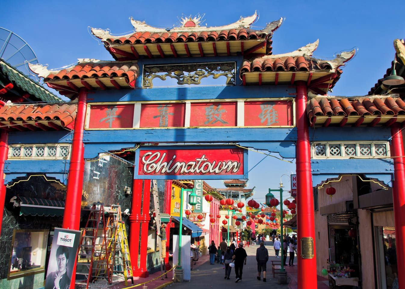 A traditional Chinese gate with the word 'Chinatown' above it, leading to a street lined with shops and red lanterns.