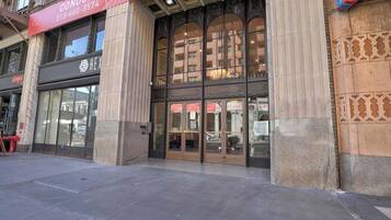 A building with a large glass facade, a prominent red banner with contact information, and a number '939' on the entrance.