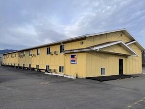 A yellow building with a sign indicating it is a hotel and extended stay.