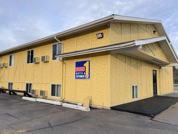 A yellow building with a sign reading "Studio Hotel & Extended Stay."