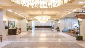 A hotel lobby with a reception desk, a chandelier, and seating areas. - Inspiring view, relaxing ambience, family favorite (Destin)